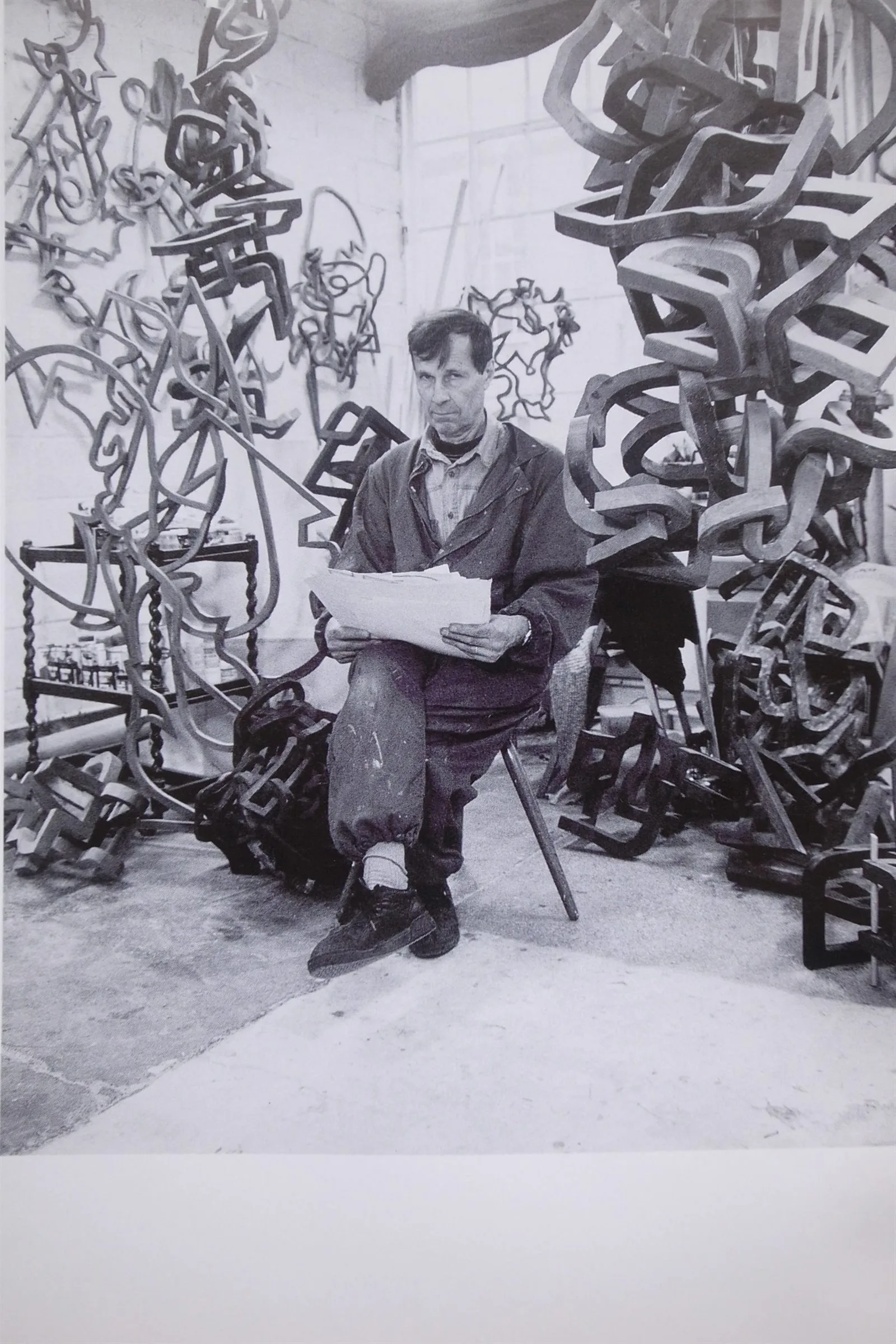 Oleg Prokofiev seated among sculptures in his London studio