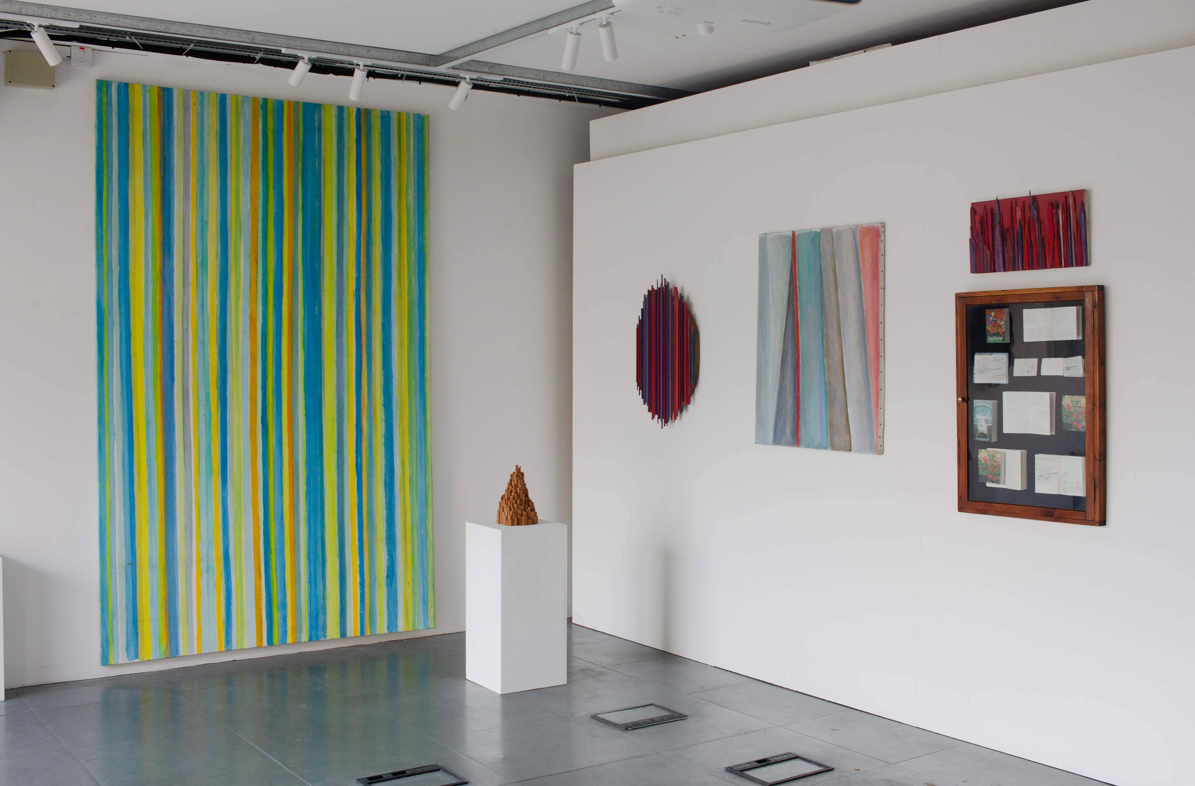 Installation view of Beyond the Line with striped paintings and sculptural works by Oleg Prokofiev